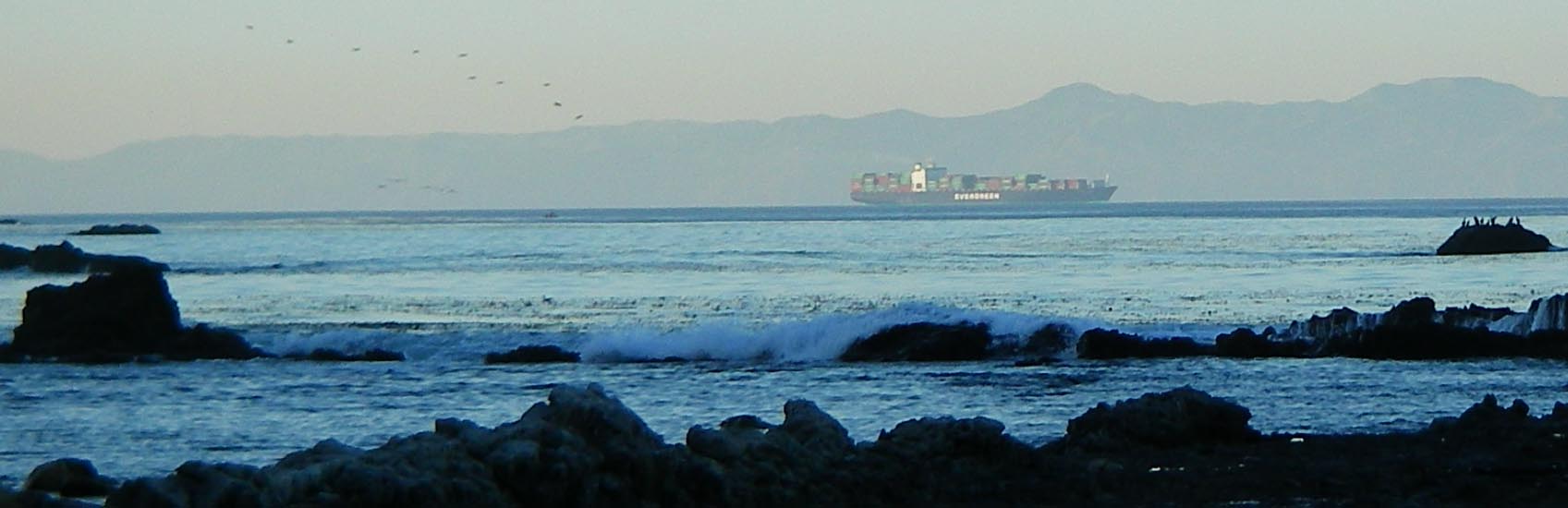 Container ship steaming eastward through the San Pedro Channel as seen from the rocks at the end of Hawthorne Blvd., Palos Verdes.  Catalina Island in the background
